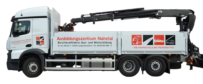 Schulfahrzeug mit Ladekran und Beschriftung des Ausbildungszentrums vor dem Gebäude